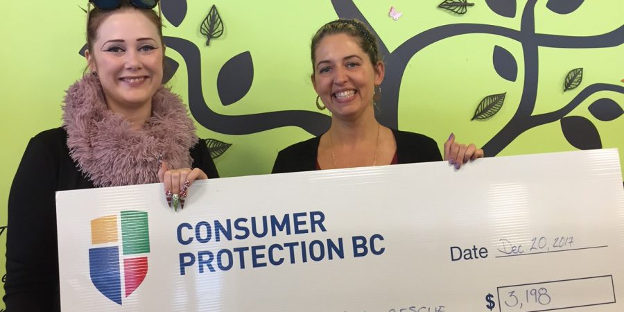 Two women holding a big cheque