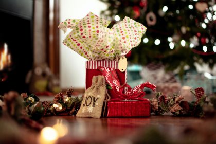 Wrapped gifts sitting by a Christmas tree