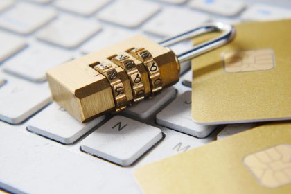 Padlock on computer keyboard with credit cards