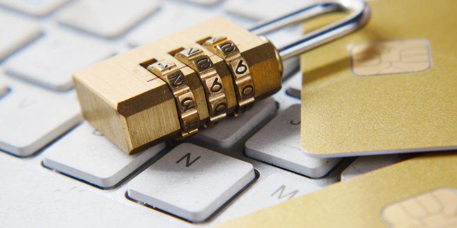Padlock on computer keyboard with credit cards