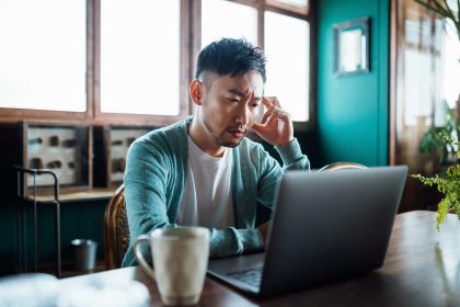 A man looks frustrated while looking at a contract on a computer