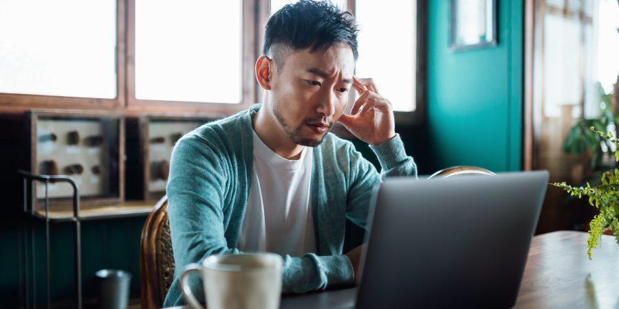 A man looks frustrated while looking at a contract on a computer
