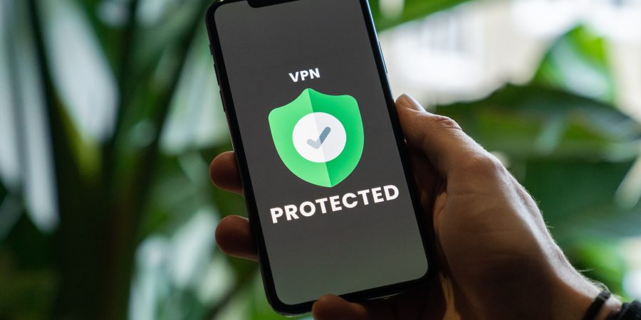 Someone holding a phone with a VPNs shield on the screen, saying "protected"