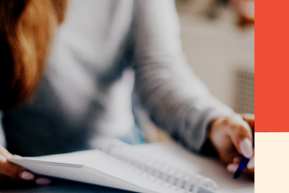 A woman writes in a notebook. Image for a blog post about how debt impacts your credit.