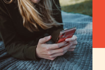 A lady sitting outside looks down at her phone. Image for a blog post on the rules debt collectors must follow in BC.