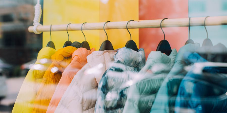 A line of different colours of the same jacket hang on a rack representing buy now, pay later plans.