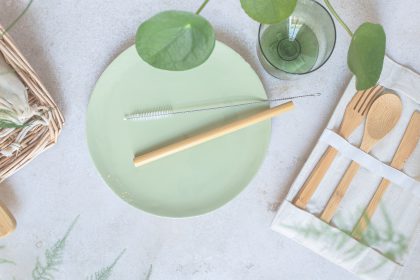 A top down view of a place setting with all eco-friendly utensils, representing eco-friendly tips people can use to save money.