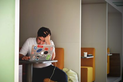 A man working at his computer with the title "payday loans: two things to know"