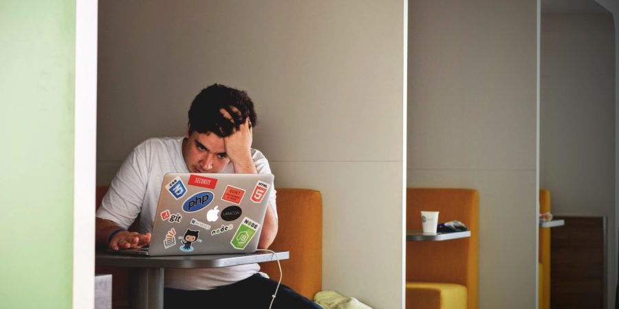 A man working at his computer with the title "payday loans: two things to know"