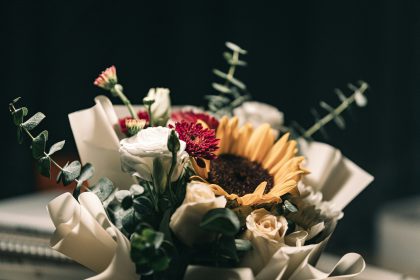 Image of flowers with black background - Watch out for obituary scams